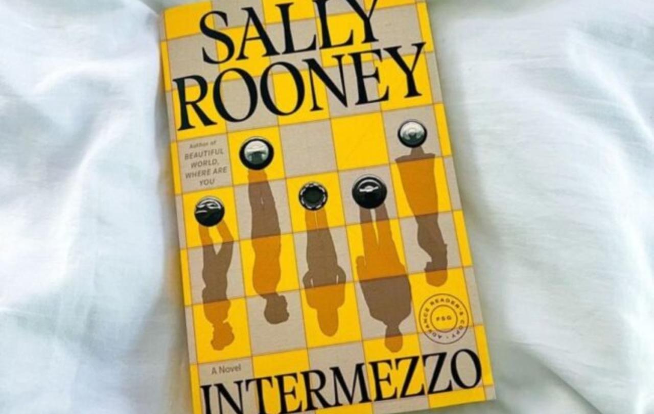 A book cover depicts a yellow and white chessboard with pieces casting shadows of people.