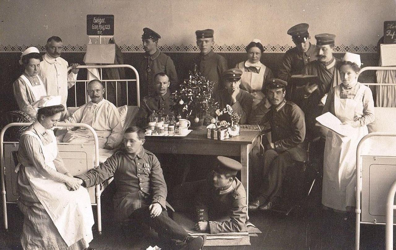 A black and white photo shows solider patients and nurses in a hospital.
