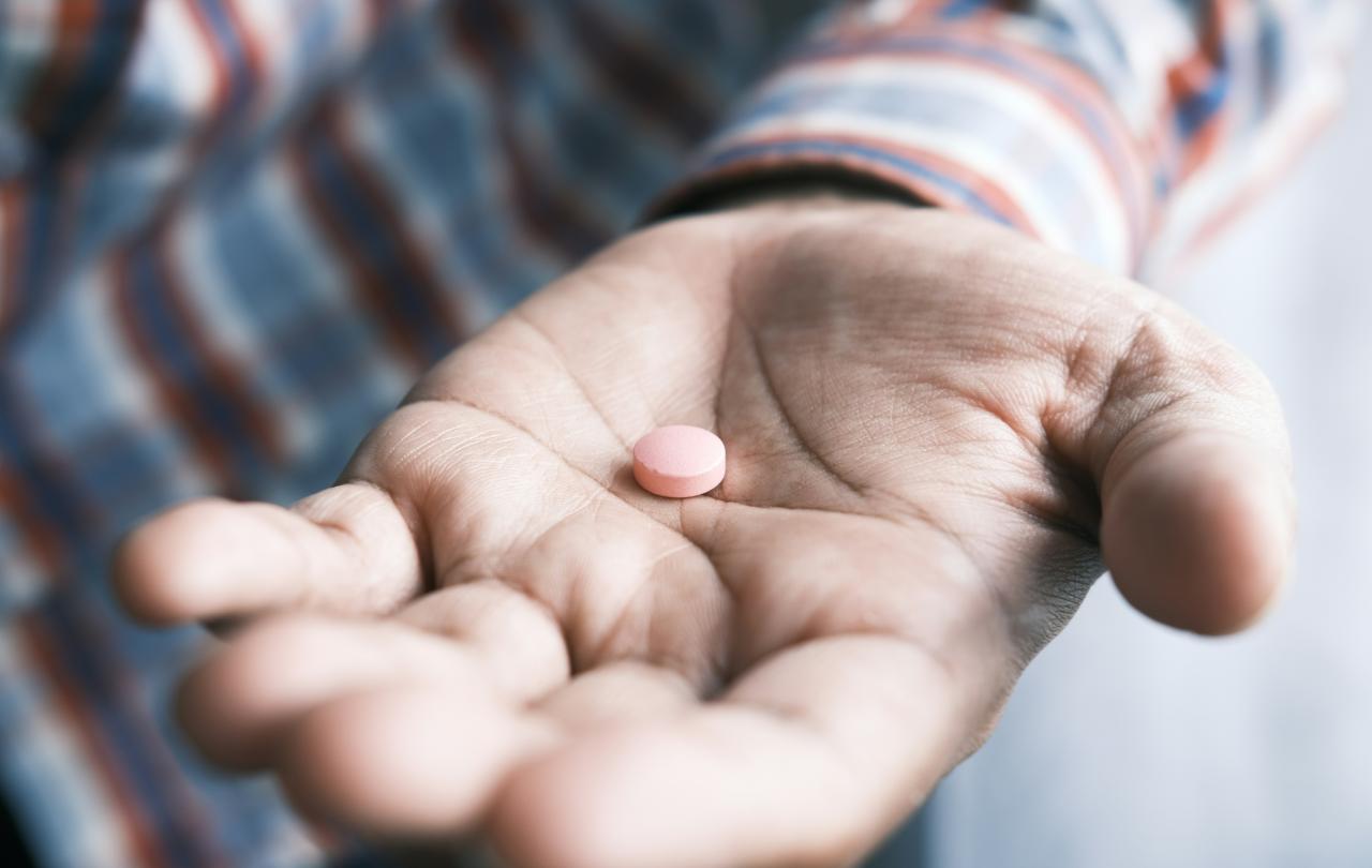 A open hand hold a pill.