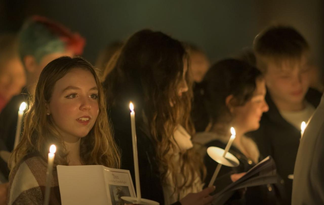 Carol singers, lit by candle light.