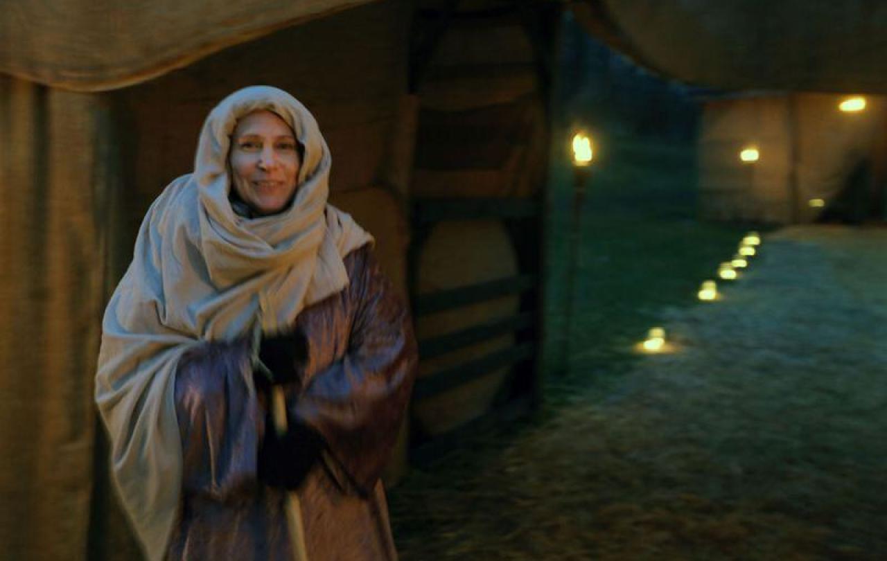 A woman dressed as a historical Middle Eastern innkeeper's wife.