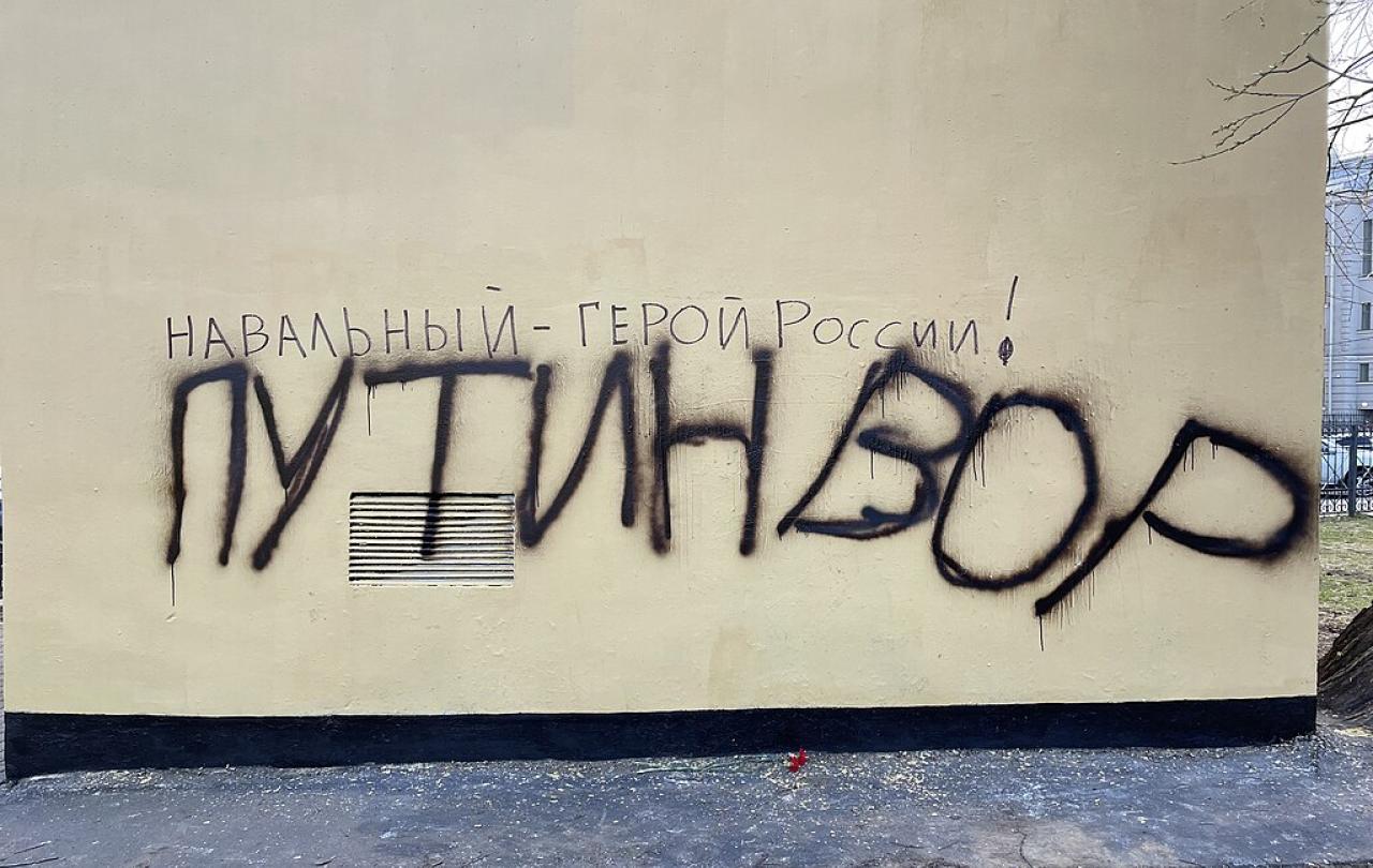 Graffiti on a wall, spells out in Russian character the name Navalny.
