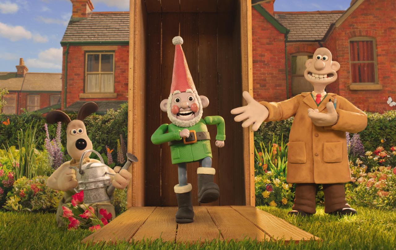 A still from a claymantion film shows three characters, Wallace, Gromit and a robot garden gnome marching out a garden shed.