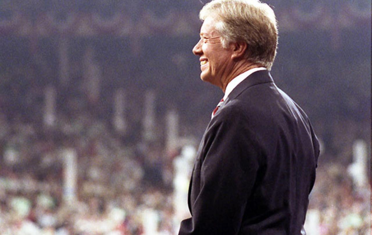 Jimmy Cater stands on a convention stage looking out over the crowd.