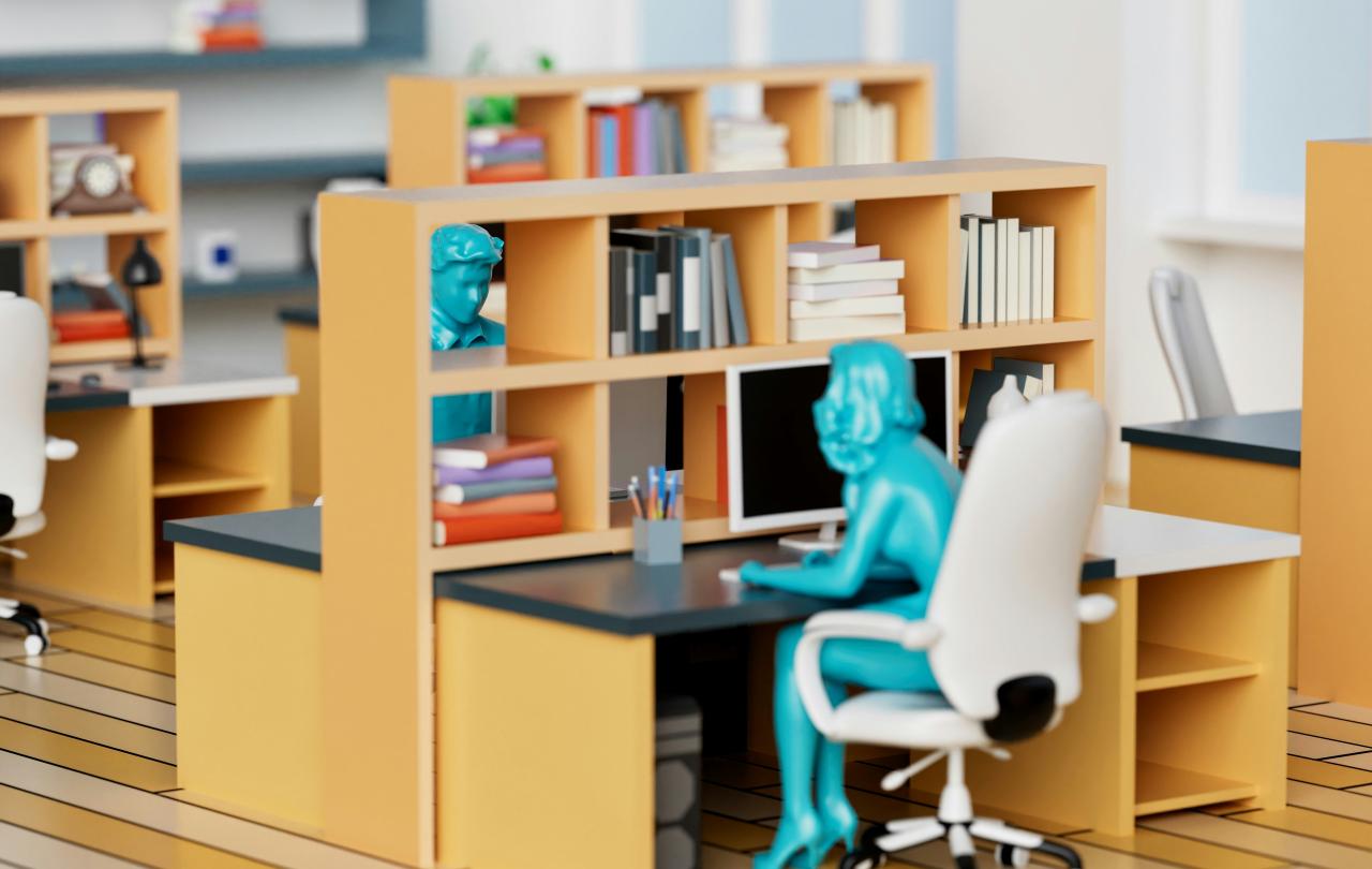 A model of an office desk and shelves, at which a green plastic person sits leaning into the desk.