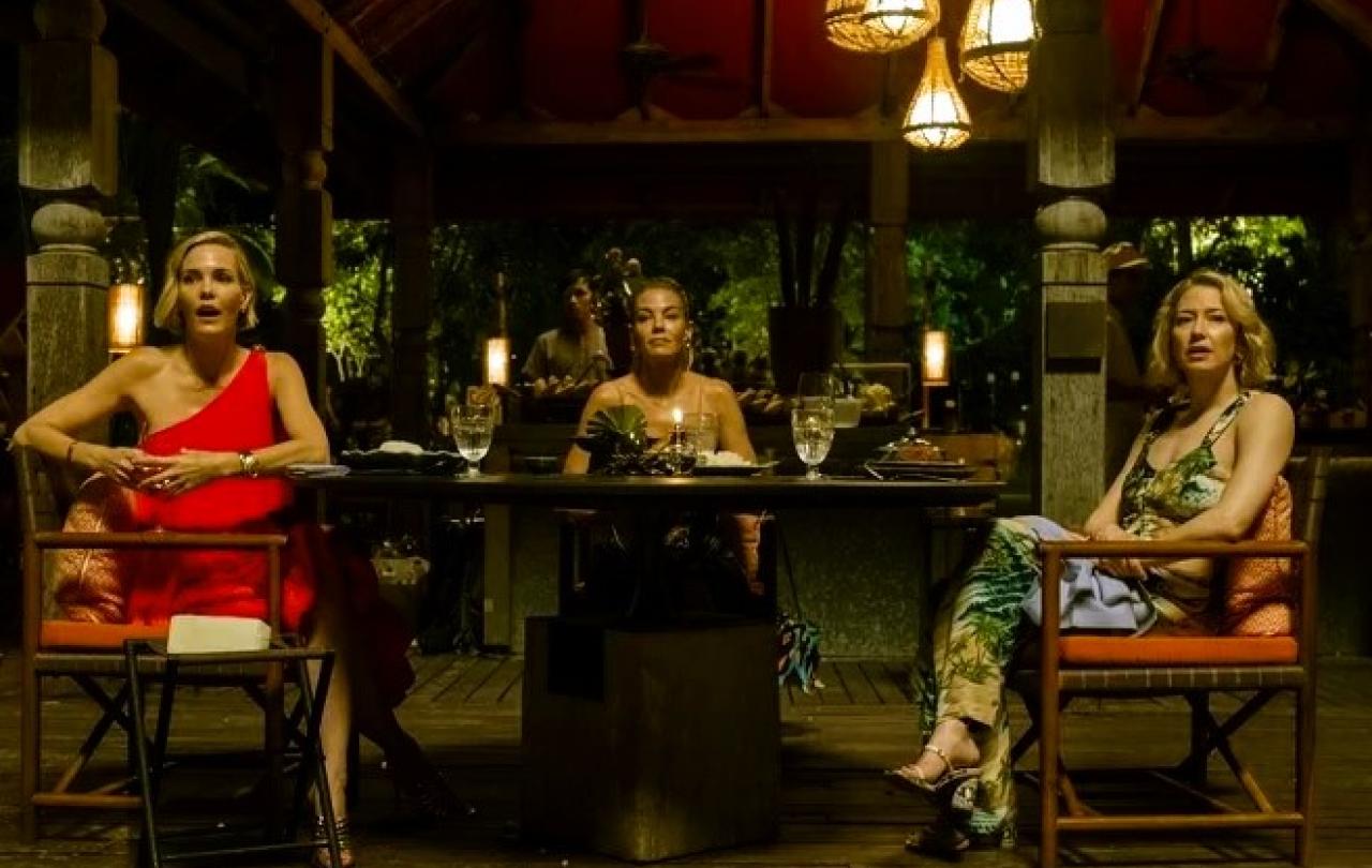 Three woman dining in a luxury hotel in Thailand, turn and look to the camera.