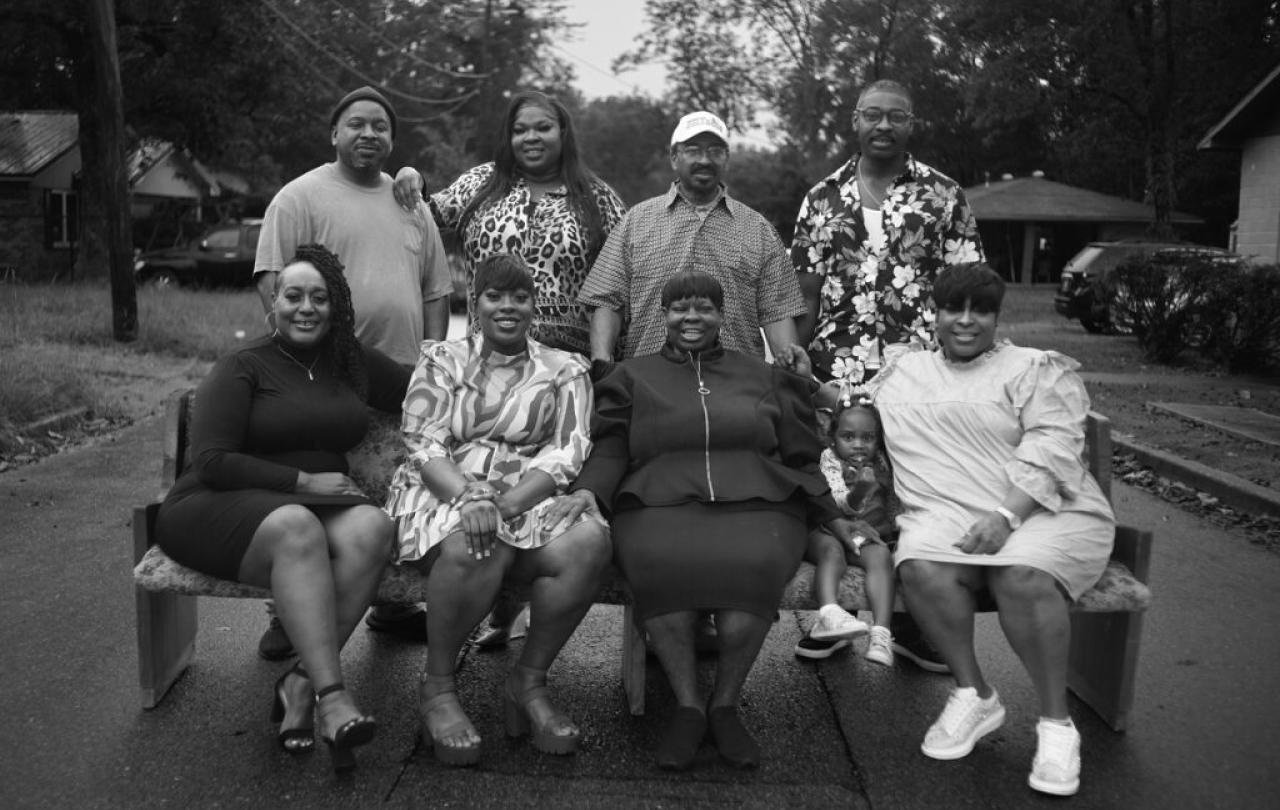 A family group stand and sit for a photo.