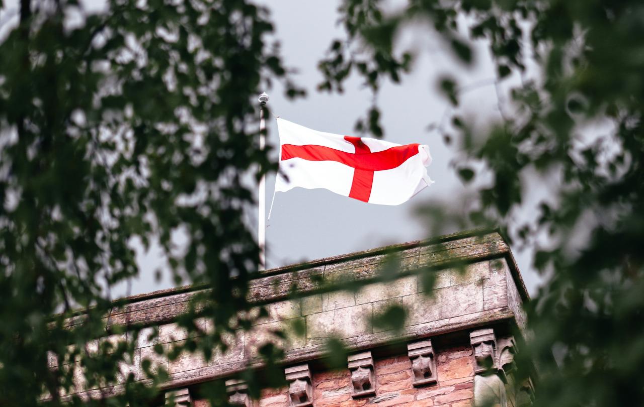 A St George's Cross flag flutters on a tower.