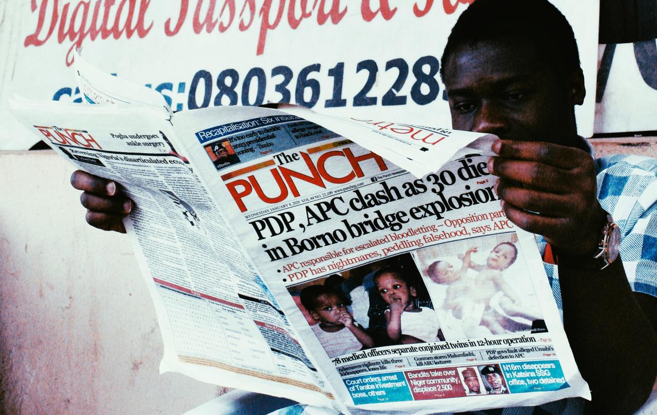 A man reads a newspaper called The Punch.
