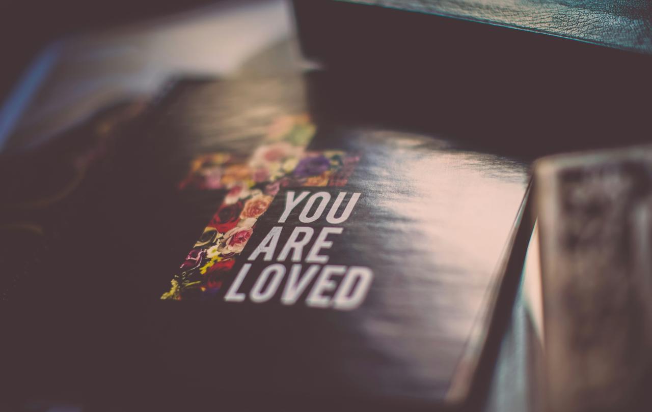 A cover of a book show a cross and the title 'You are loved'.