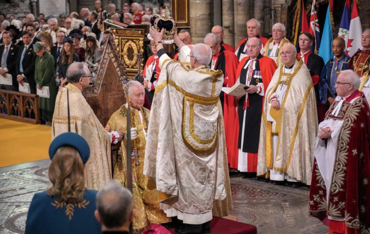 An archbishop raises a crown about the head of King Charles.