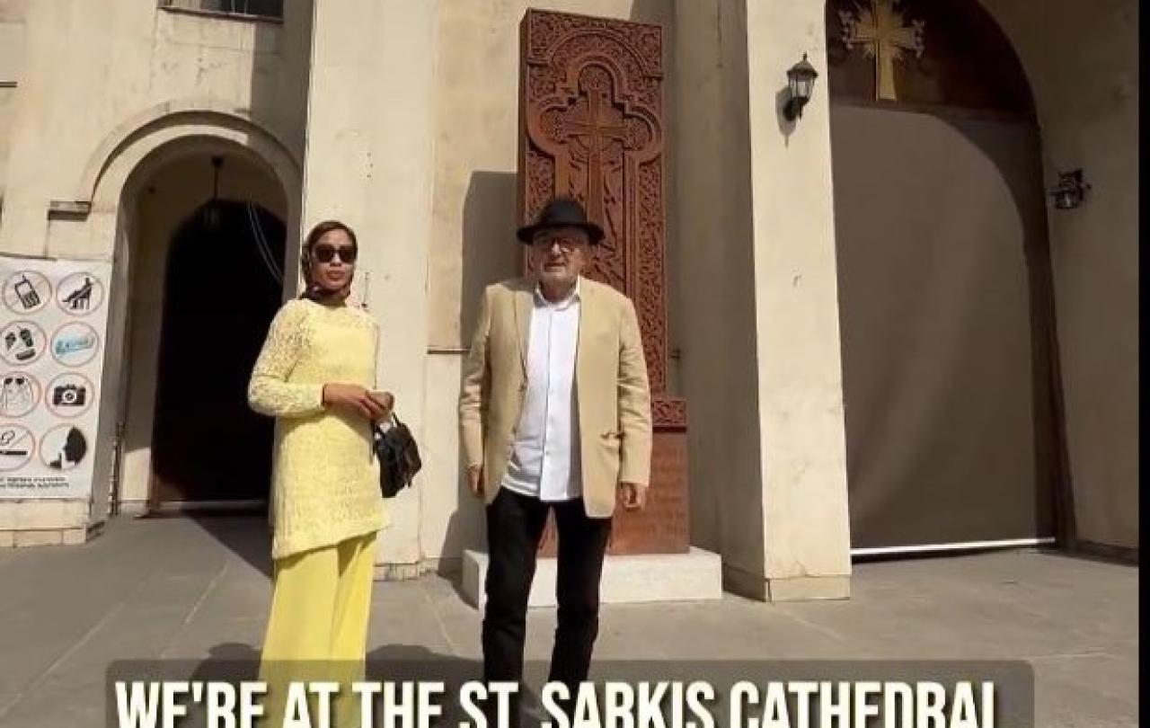 A couple stand on the steps of a cathedral in Iran.