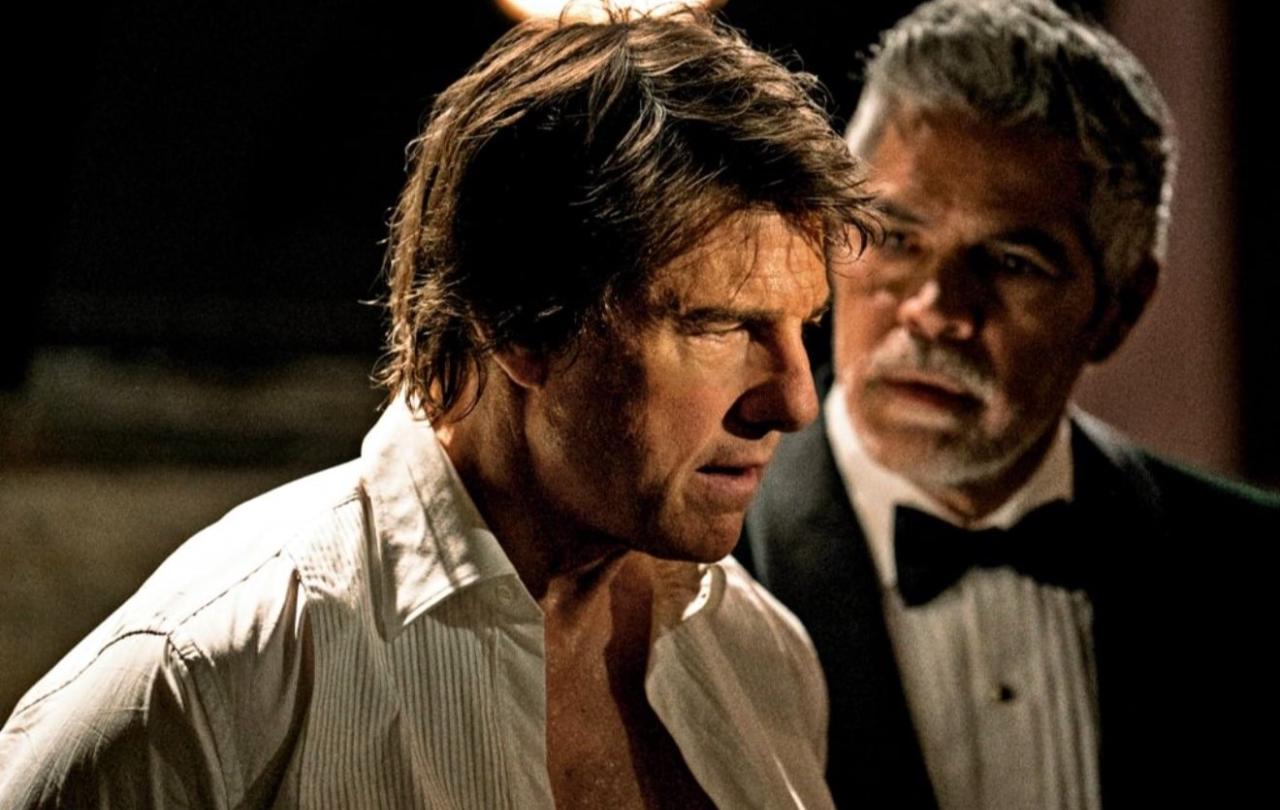 Tom Cruise playing Ethan Hunt in an open necked shirt looks perplexed.