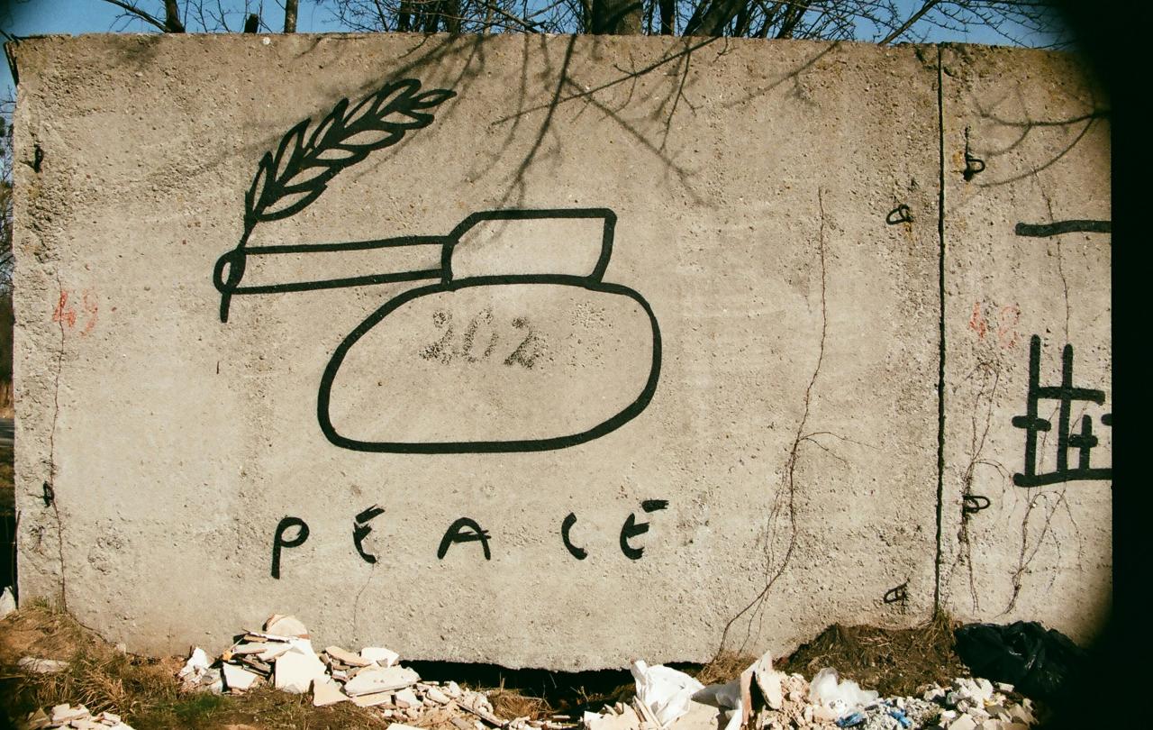 Graffiti of a tank with a peace laurel coming out of its barrel.