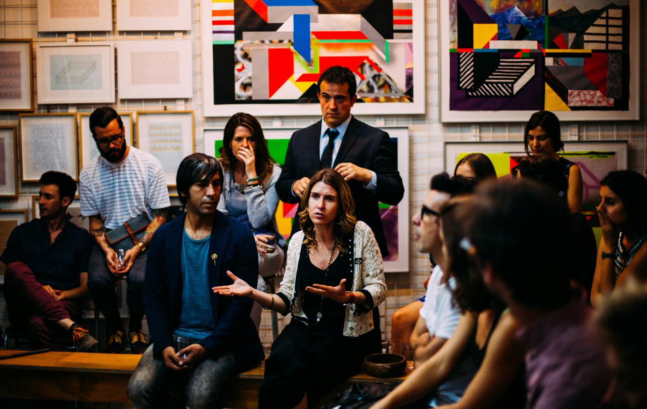 A member of an audience makes a point while gesturing.