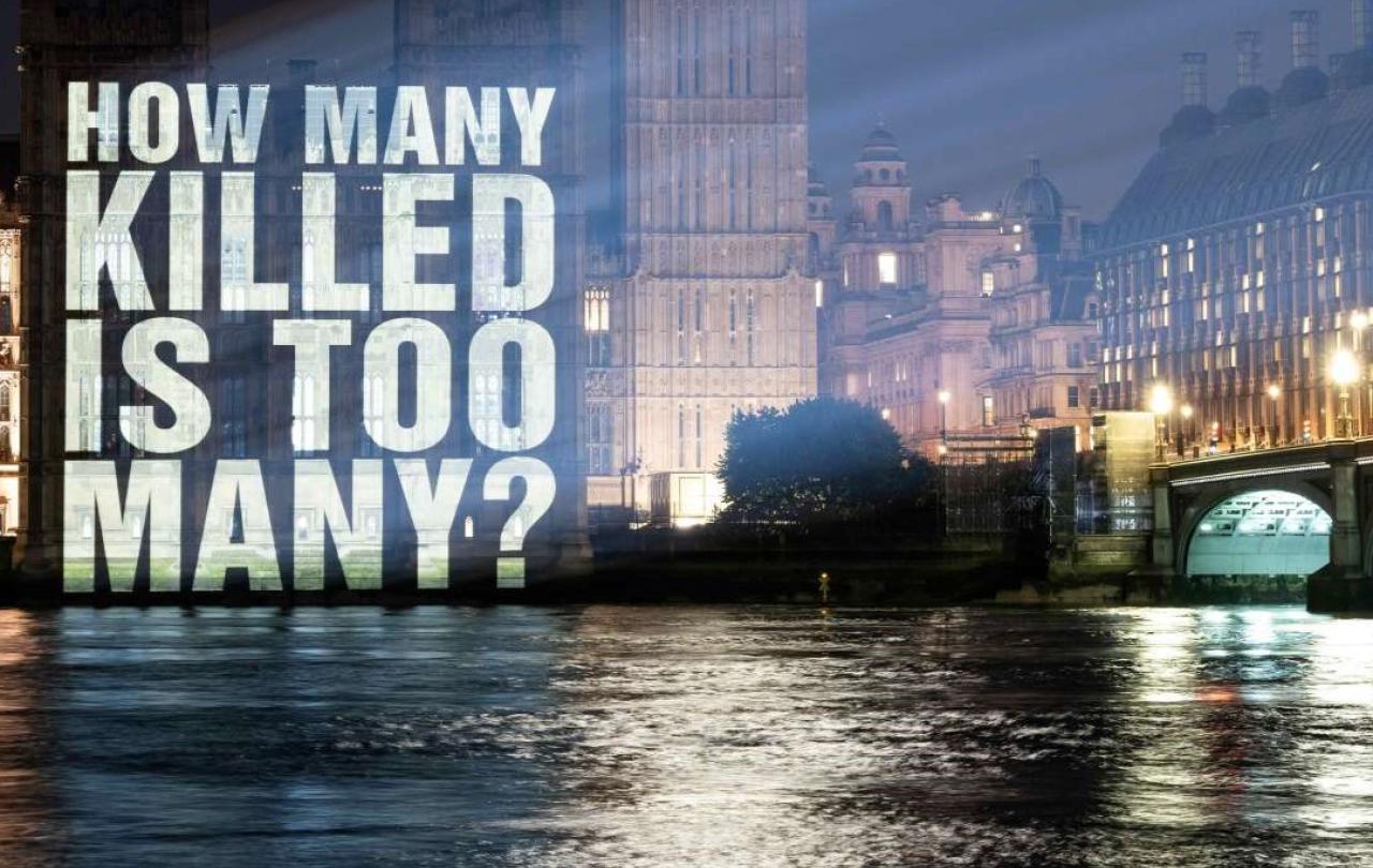 A sign projected on to the Houses of Parliament reads: how many is too many.