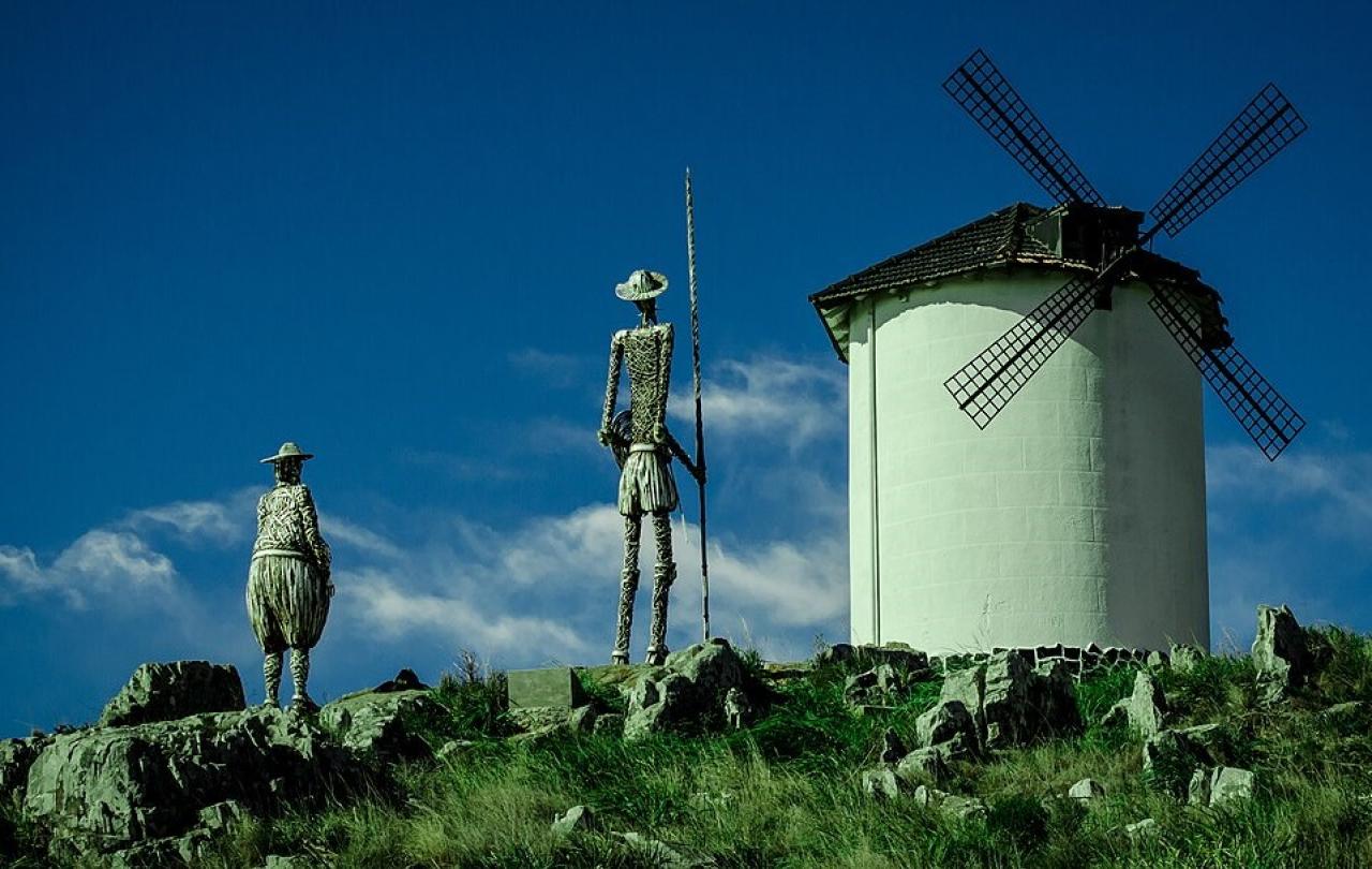 Statues of Don Quixote and Sancho Panza point toward a windmill