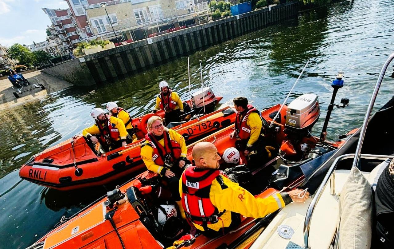 Two small lifeboats raft together on a river rescue.