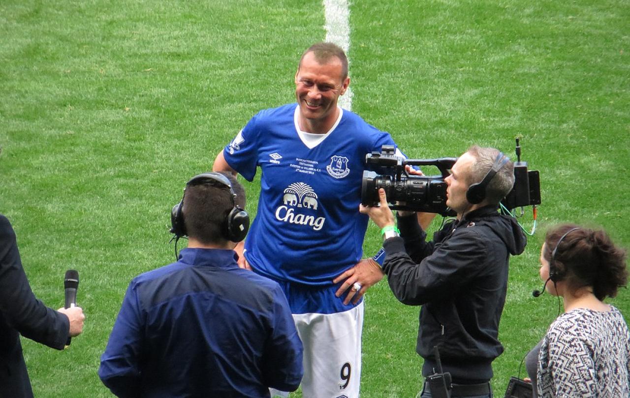 A footballer is interviewed on the side line.
