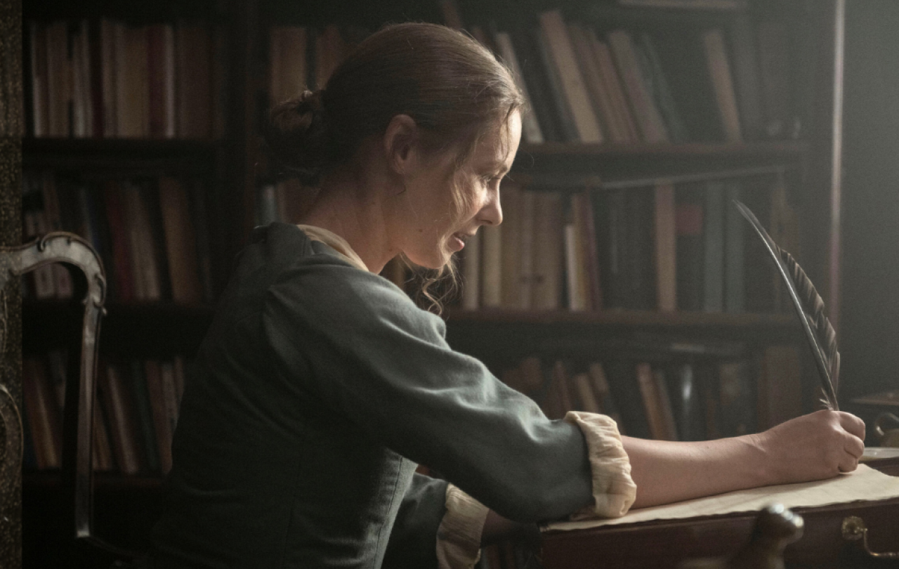 A regency woman writes with a quill
