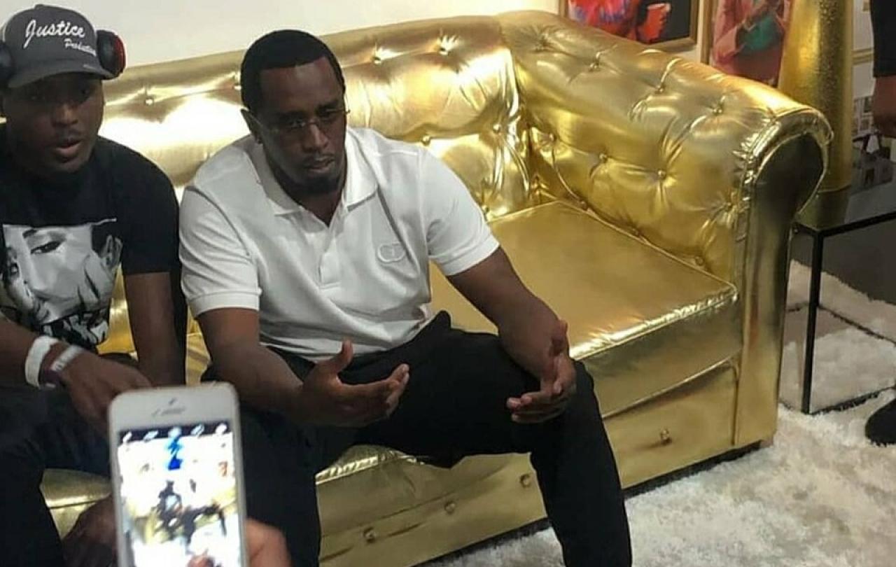 Sean Combs sits on a golden couch.