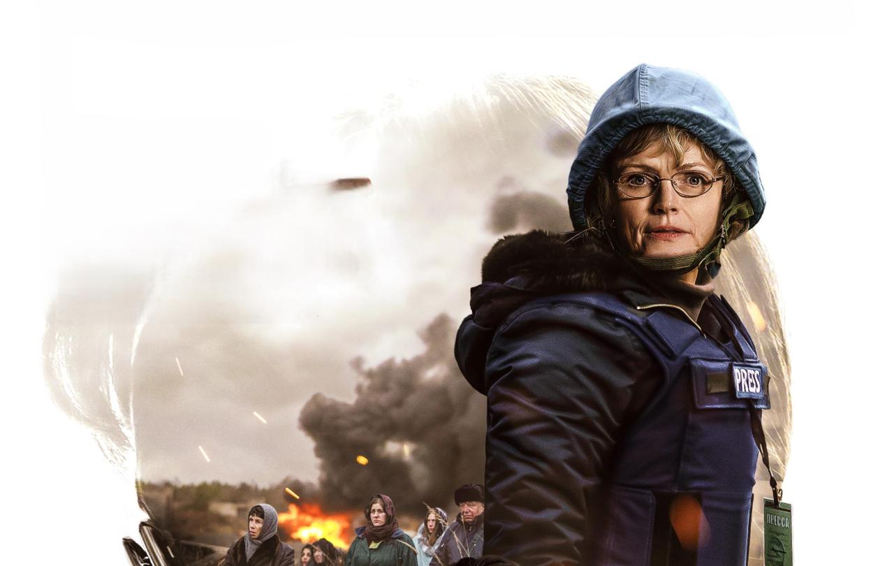 A journalist wearing a body armour and a helmet looks defiant
