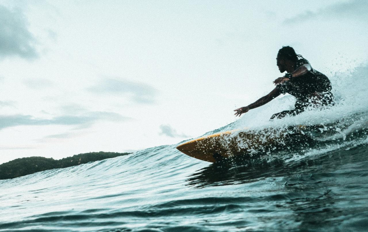 A surfer carves a turn on a wave.