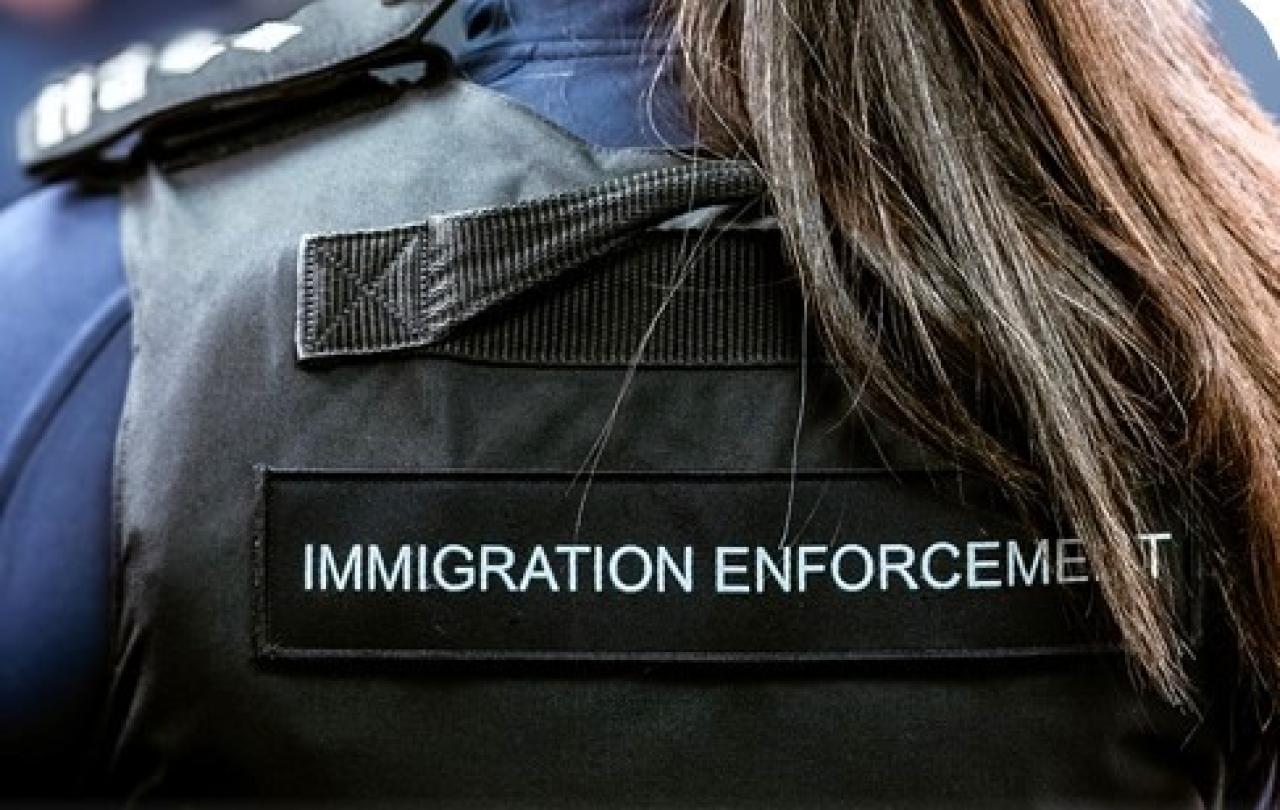 A Border Force officer wears body armour with Immigration Enforcement written on the back