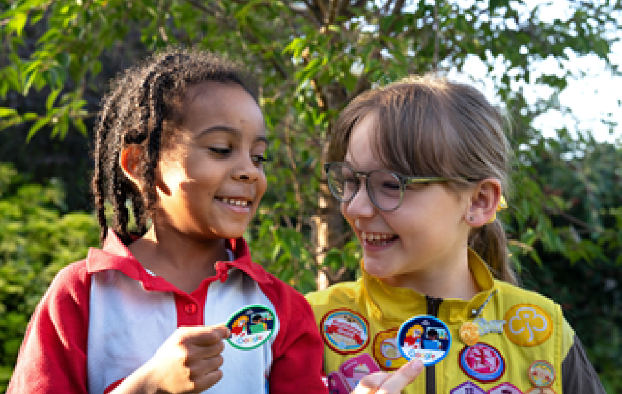 Two Brownies point out their badges.