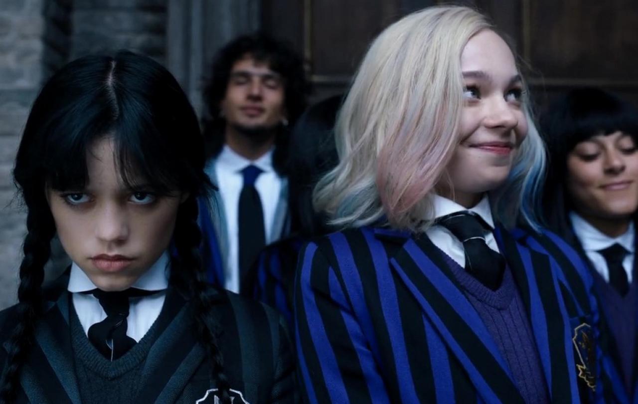 Wednesday Adams scowls while Enid smiles.
