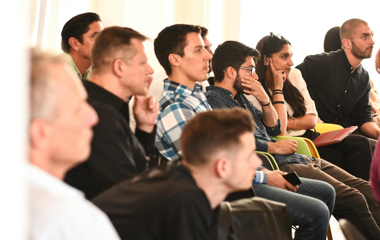 young people listen, and ponder, to a speaker off screen.