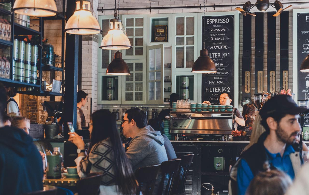 People sit in a busy cafe.
