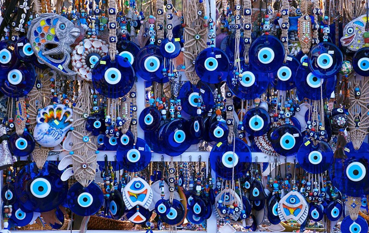 Blue evil eye charms hang among a jewellery display
