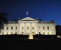 The White House illuminated against the night sky.
