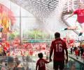 A CGI image of a son and dad holding hands on the concourse of a modern stadium.