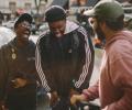 Three friends in the street laugh together.