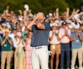 A golf clutches his face after winning a competition