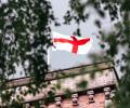 A St George's Cross flag flutters on a tower.