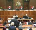 A court sits, with judges raised above the others.