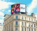 A digital billboard on top of a London building reads: Make Earth Day Everyday.
