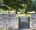 A gate to a churchyard displays a sign saying polling station.