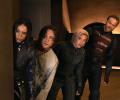 Four characters from a film loop warily to the side.