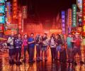 Contestants in Race Across the world stand in front of neon-lit Chinese street scene