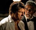 Tom Cruise playing Ethan Hunt in an open necked shirt looks perplexed.