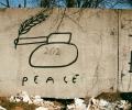 Graffiti of a tank with a peace laurel coming out of its barrel.
