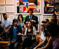 A member of an audience makes a point while gesturing.