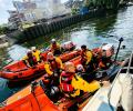 Two small lifeboats raft together on a river rescue.