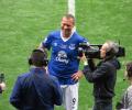 A footballer is interviewed on the side line.