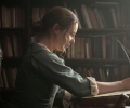 A regency woman writes with a quill