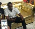Sean Combs sits on a golden couch.